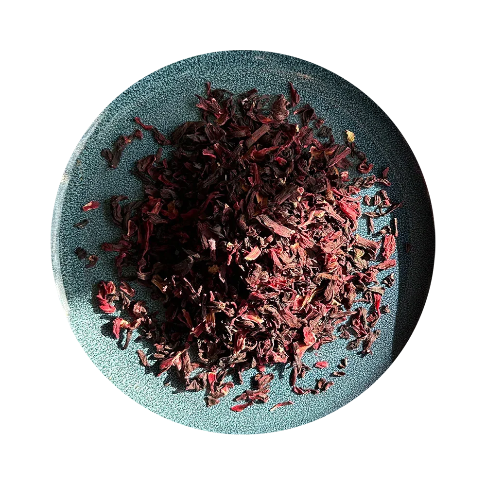Dried hibiscus tea leaves on a textured teal plate, organic herbal blend for healthy drinking