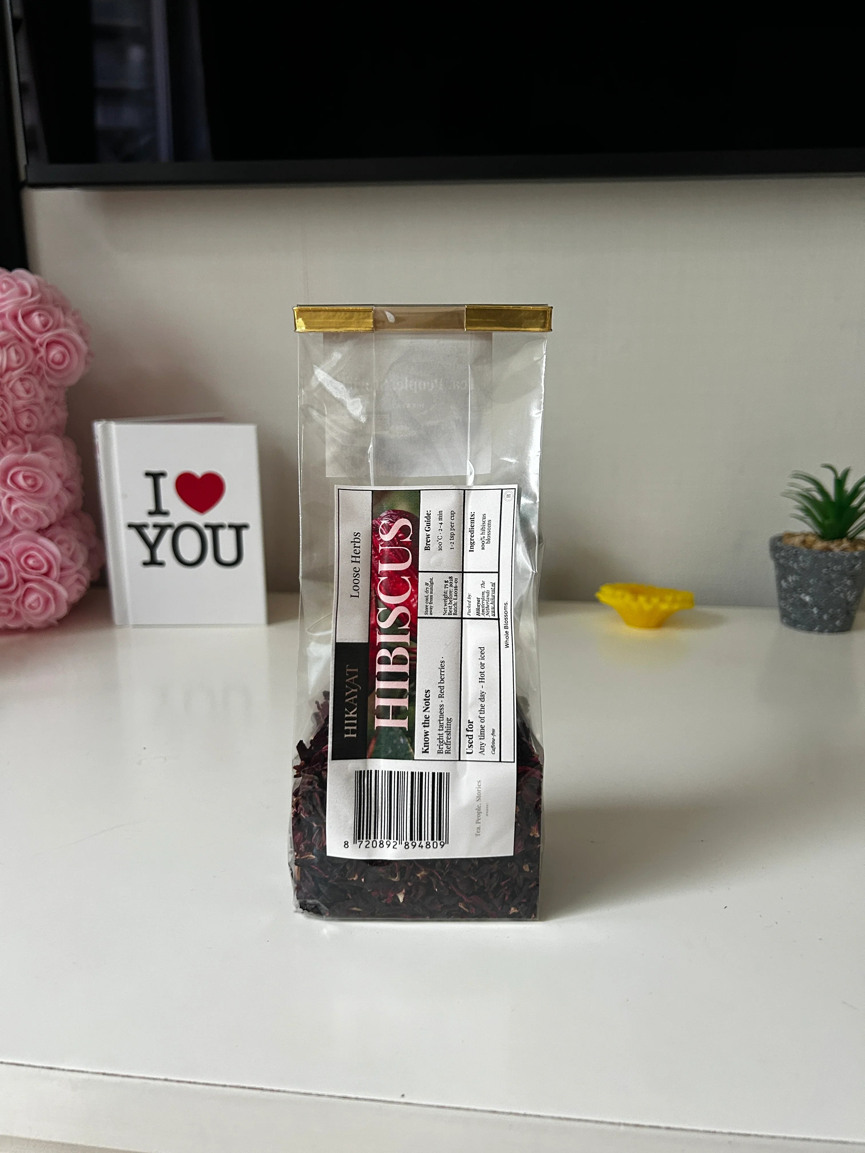 Hibiscus loose herb tea in clear bag, organic caffeine-free blend with red berry notes, perfect for hot or iced tea