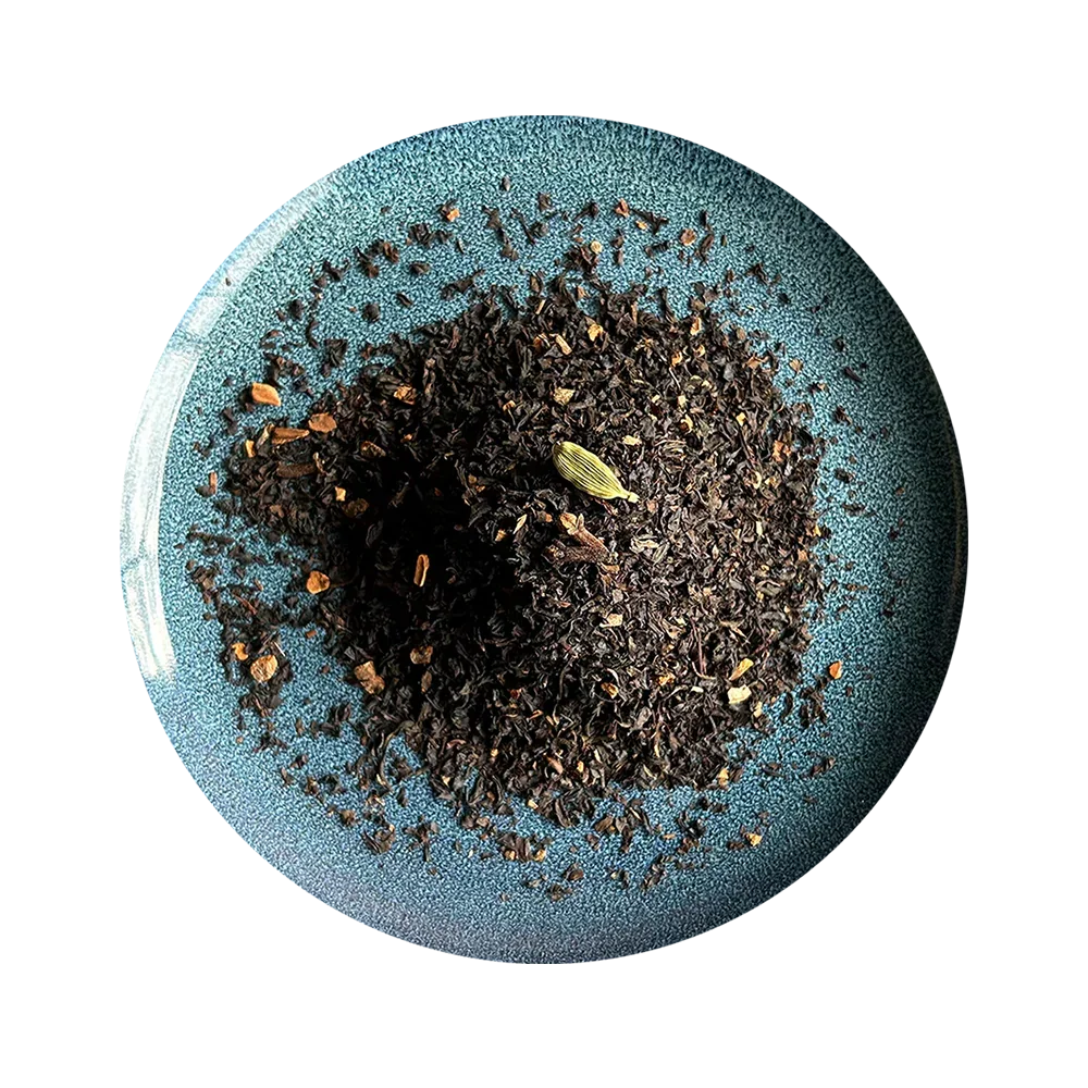 Loose leaf black tea blend with cardamom on a blue plate, organic and aromatic